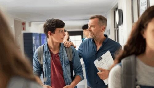 High school teacher and student in hallway