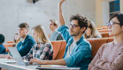 Student raises hand during a college class